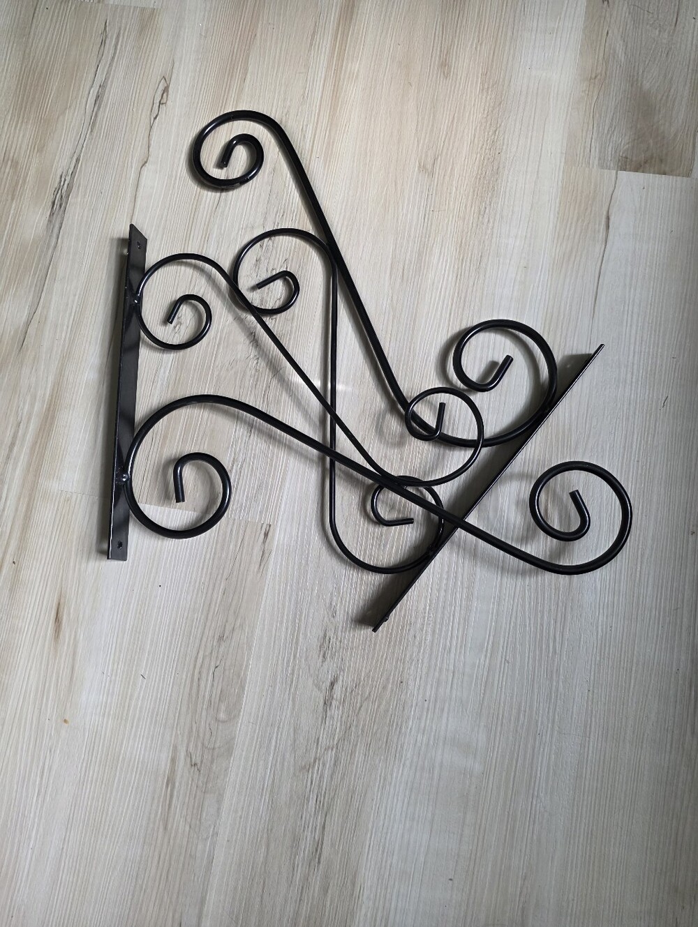 Black decorative iron wall-mounting brackets with a scroll and swirl design